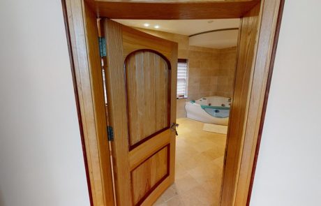 curved wooden door leading into bathroom